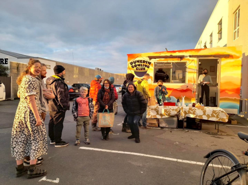 Shows a crowd of people around their original food truck